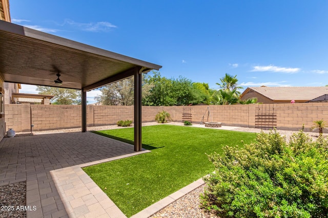 view of yard featuring ceiling fan and a patio