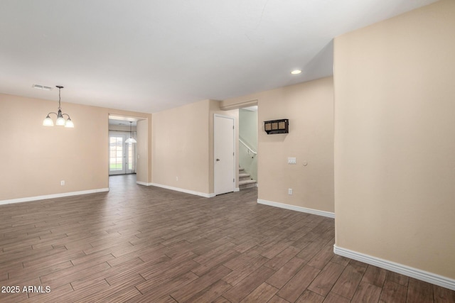 unfurnished room with a notable chandelier