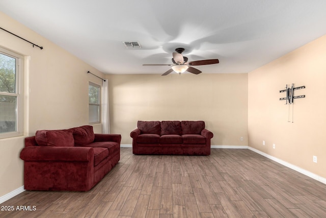 living room with wood-type flooring, a wealth of natural light, and ceiling fan