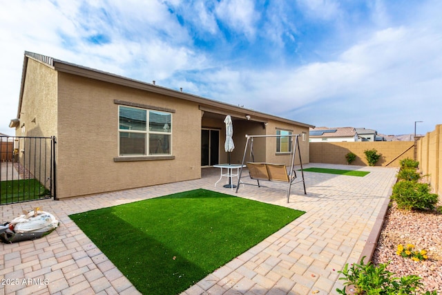 rear view of house with a patio and a lawn