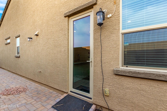 view of exterior entry with a patio