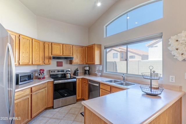 kitchen with appliances with stainless steel finishes, a sink, under cabinet range hood, high vaulted ceiling, and light countertops