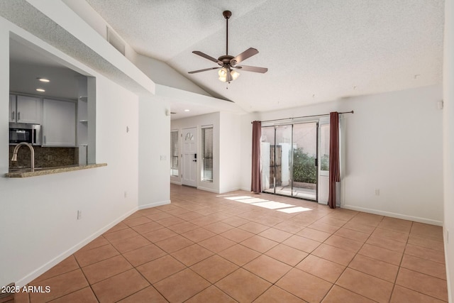1425 E Commerce Ave, Gilbert, AZ 85234 - empty room featuring ceiling fan, light tile patterned floors, lofted ceiling, a textured ceiling, and baseboards