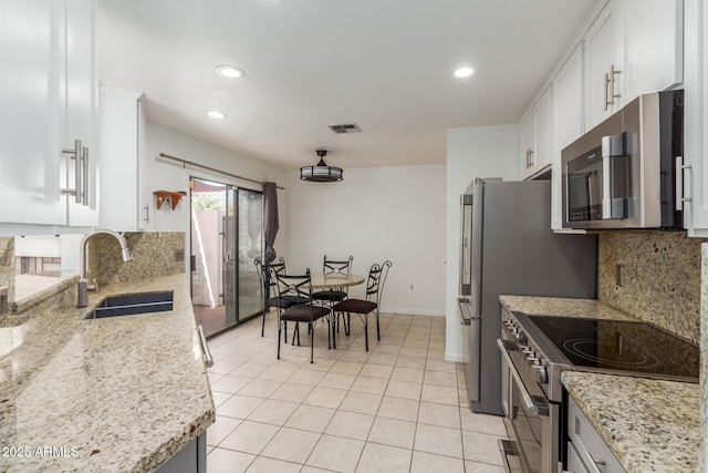 1425 E Commerce Ave, Gilbert, AZ 85234 - kitchen with stainless steel appliances, a sink, white cabinetry, decorative backsplash, and recessed lighting