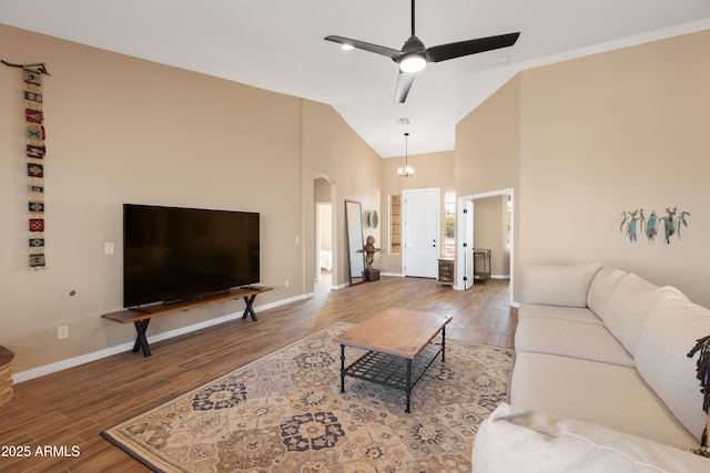 living room with a ceiling fan, arched walkways, baseboards, and wood finished floors