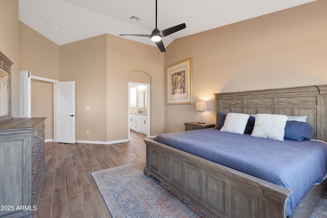 bedroom featuring ensuite bath, wood finished floors, visible vents, and baseboards