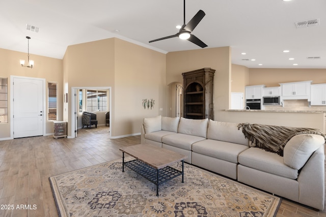 living area with visible vents, light wood-style flooring, and baseboards