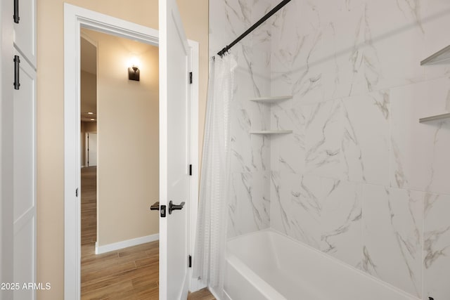 full bath with shower / tub combo, baseboards, and wood finished floors