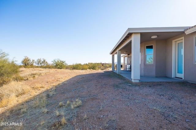 view of property exterior featuring stucco siding and a patio