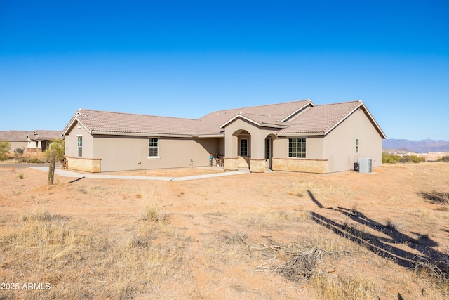 ranch-style home with cooling unit, a patio area, a tiled roof, and stucco siding