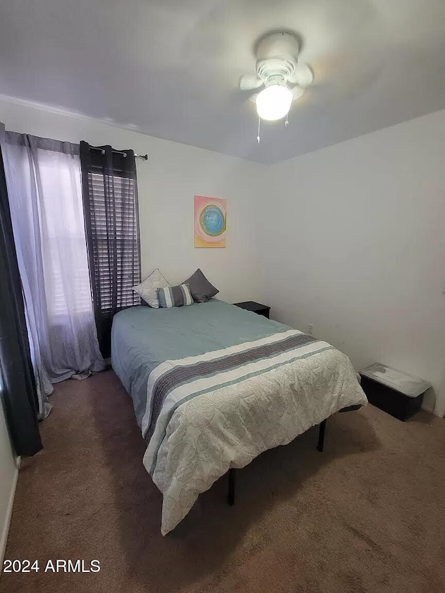 bedroom featuring ceiling fan and dark carpet