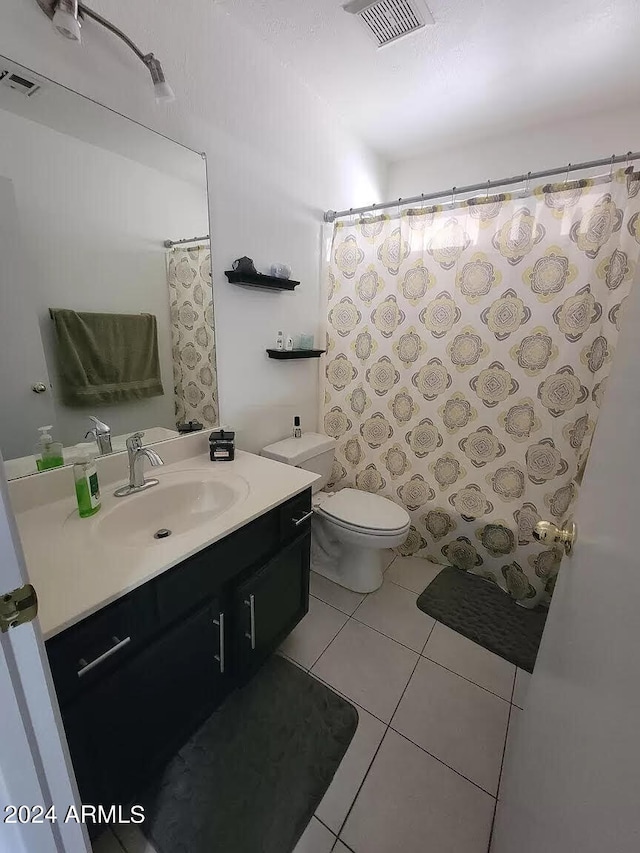 bathroom featuring tile patterned flooring, vanity, and toilet