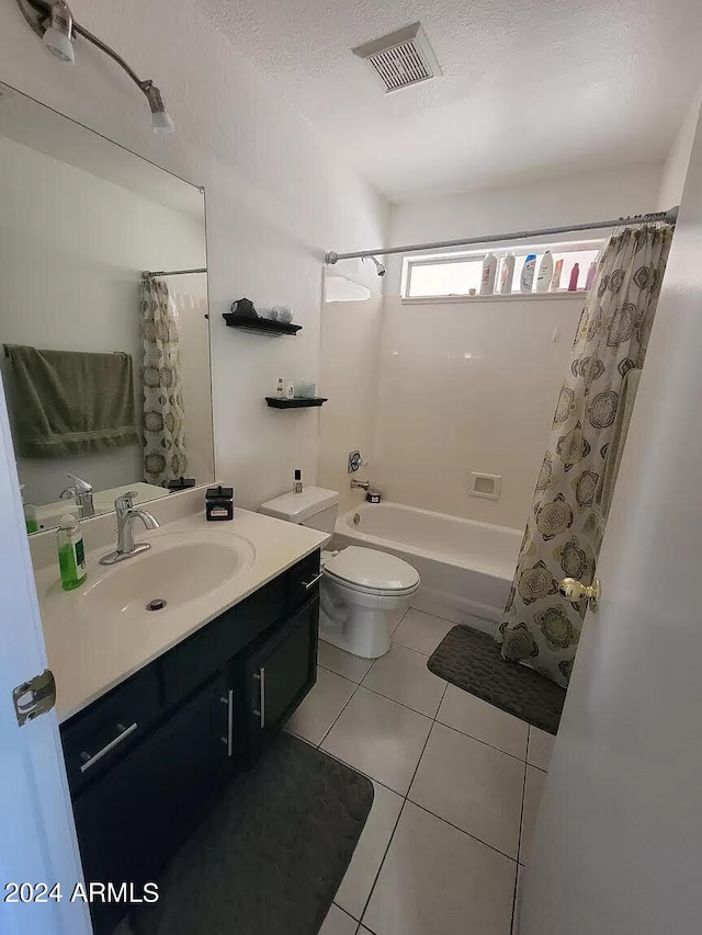 full bathroom featuring toilet, tile patterned flooring, vanity, shower / tub combo, and a textured ceiling