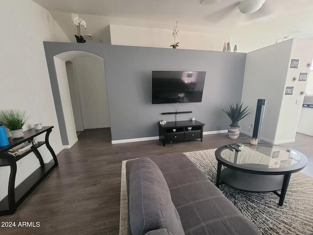 living room with ceiling fan and dark wood-type flooring