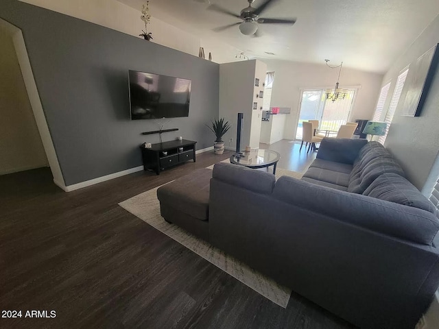 living room with ceiling fan with notable chandelier and dark hardwood / wood-style floors