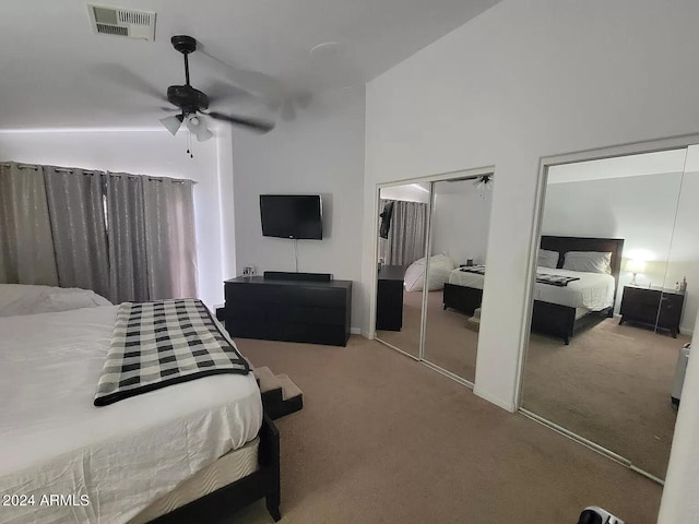 carpeted bedroom with ceiling fan, high vaulted ceiling, and multiple closets