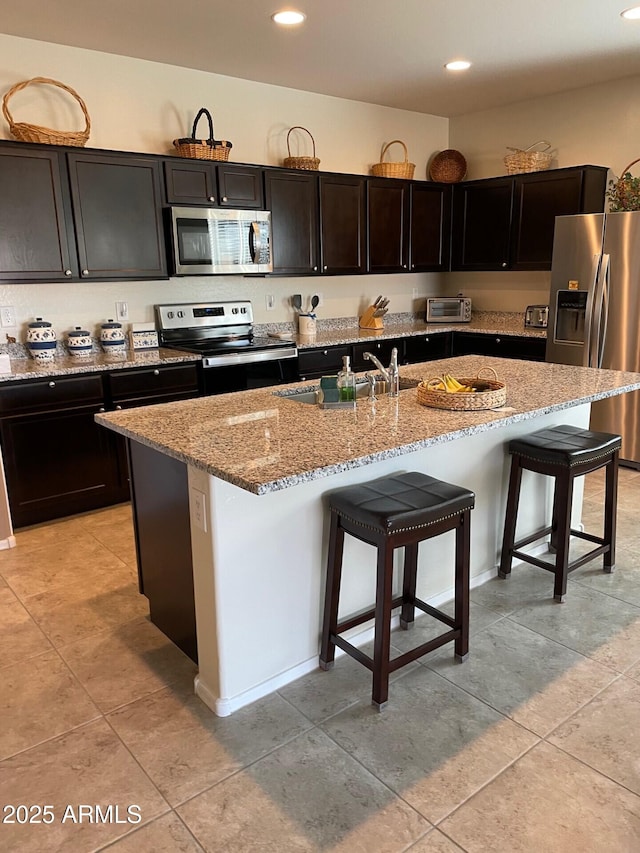 kitchen featuring a center island with sink, a breakfast bar, stainless steel appliances, and sink