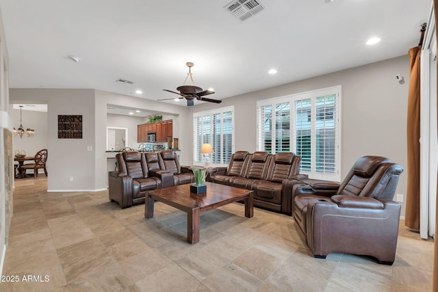 living room featuring ceiling fan with notable chandelier