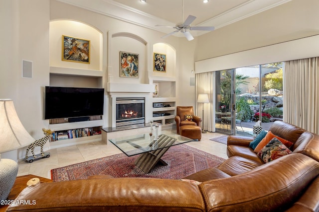 tiled living room featuring ceiling fan, built in features, and crown molding