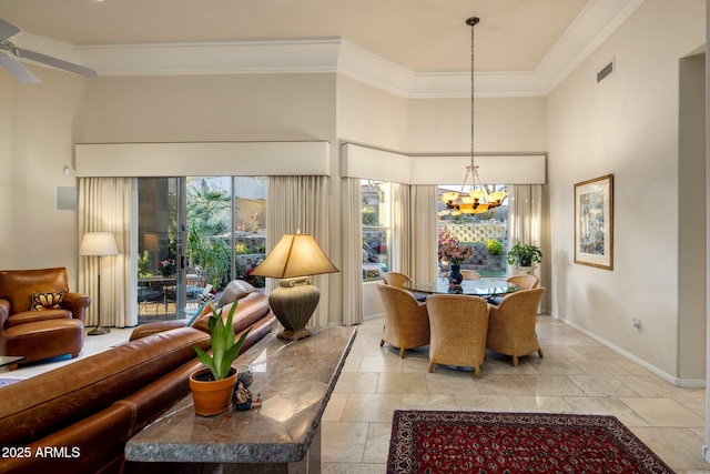 dining room with a high ceiling, ceiling fan with notable chandelier, and crown molding