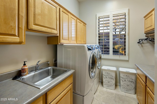 laundry room with cabinets, light tile patterned floors, washer and dryer, and sink