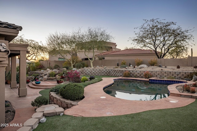 pool at dusk with a patio