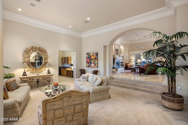 carpeted living room with ornate columns and ornamental molding