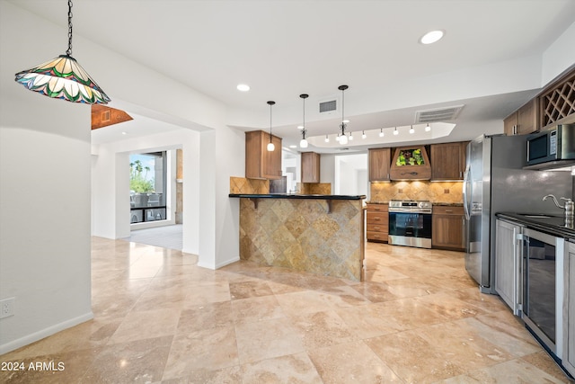 kitchen with wine cooler, decorative light fixtures, appliances with stainless steel finishes, kitchen peninsula, and decorative backsplash