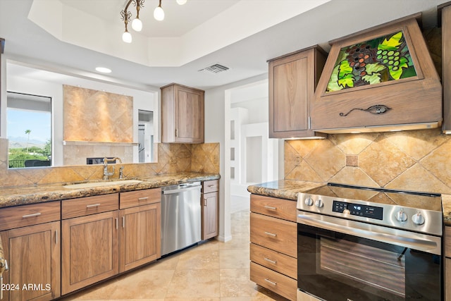 kitchen featuring sink, a tray ceiling, stainless steel appliances, and light stone countertops