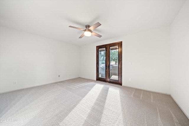 carpeted empty room with french doors and ceiling fan