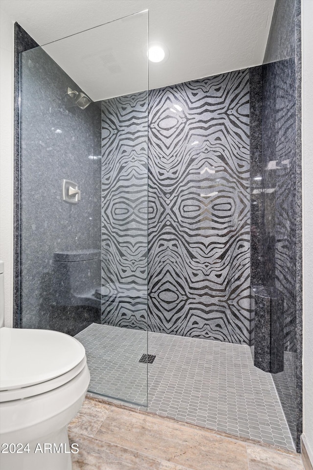 bathroom with tiled shower and toilet