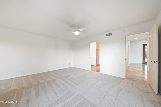 spare room featuring light carpet and ceiling fan