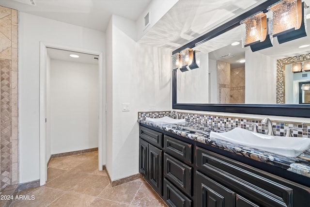 bathroom featuring tasteful backsplash, vanity, and tiled shower