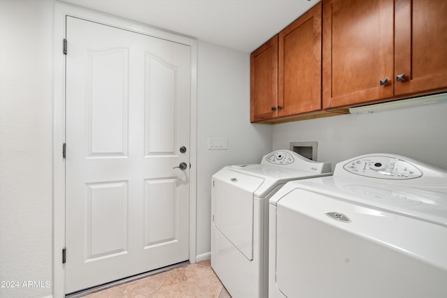 laundry area featuring light tile patterned flooring, cabinets, and separate washer and dryer