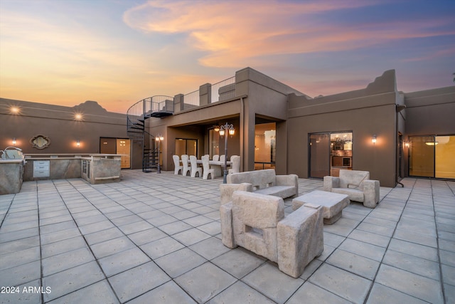 patio terrace at dusk featuring exterior kitchen