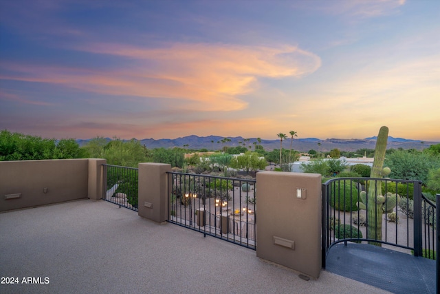 balcony at dusk featuring a mountain view