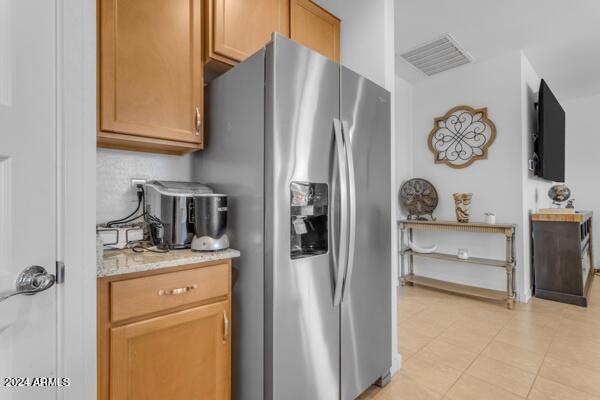 kitchen featuring light tile patterned floors and stainless steel fridge with ice dispenser