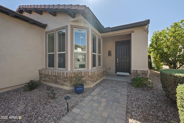 entrance to property featuring stucco siding