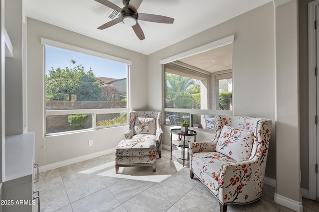 sitting room with baseboards, plenty of natural light, and a ceiling fan