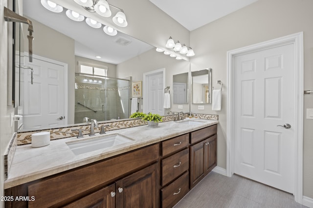 full bathroom with double vanity, visible vents, a stall shower, and a sink