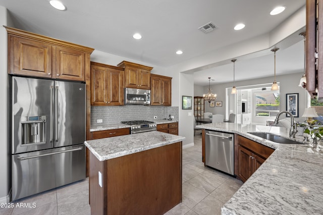 kitchen with visible vents, a sink, backsplash, stainless steel appliances, and light stone countertops