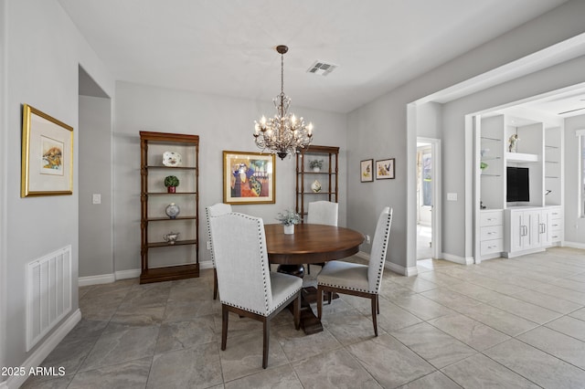 dining room with built in features, visible vents, baseboards, and an inviting chandelier