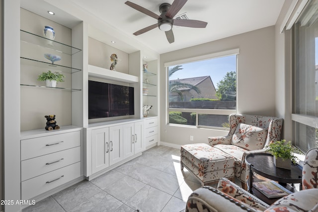 living room featuring built in shelves and ceiling fan