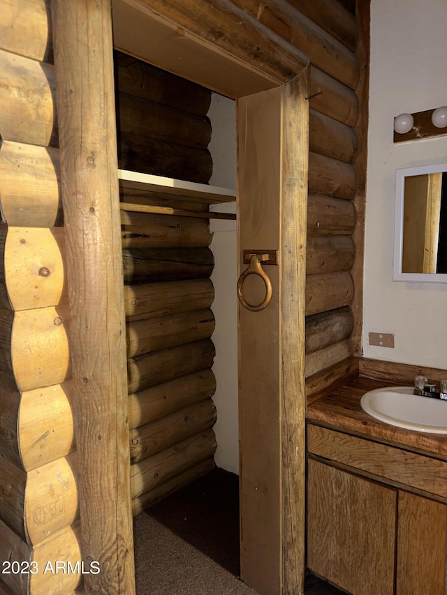 bathroom with vanity and rustic walls