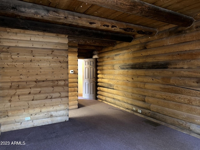 carpeted spare room with log walls, wood ceiling, and beamed ceiling