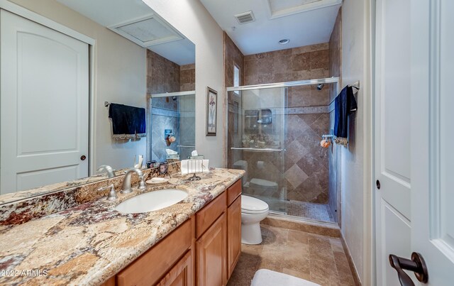 bathroom featuring tile patterned flooring, a shower with shower door, vanity, and toilet