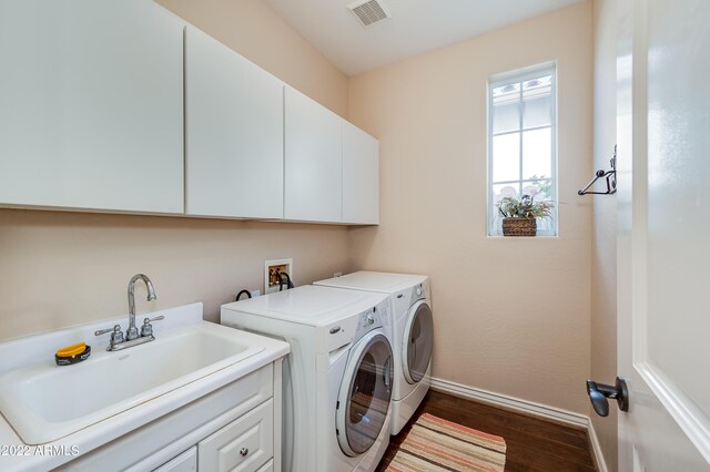 laundry area featuring cabinets, dark hardwood / wood-style flooring, washing machine and dryer, and sink