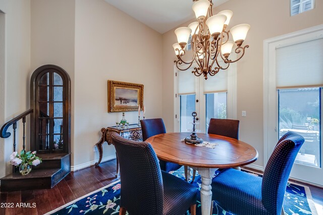 dining space featuring dark wood-type flooring and a chandelier