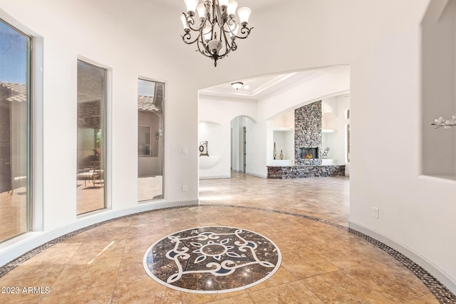 corridor with ornamental molding and an inviting chandelier