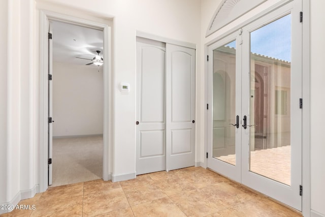 interior space featuring ceiling fan, french doors, and light colored carpet